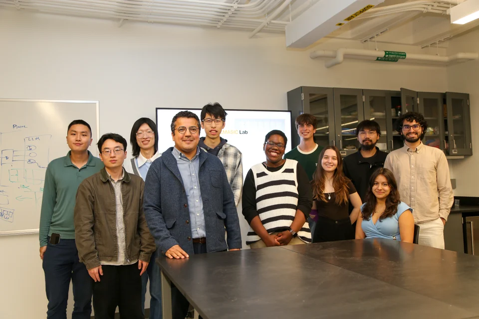 ReaLLMASIC Lab team gathered around a workbench in the laboratory
