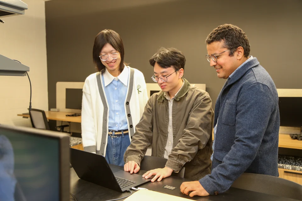 Three people reviewing a laptop together in the laboratory